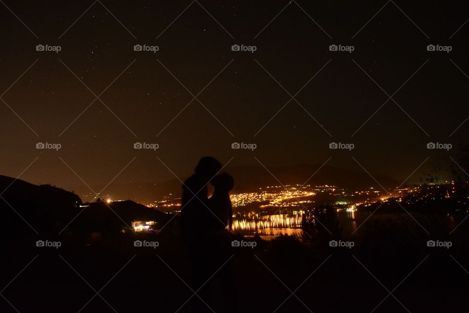 Silhouetted kiss with a beautiful city back drop 