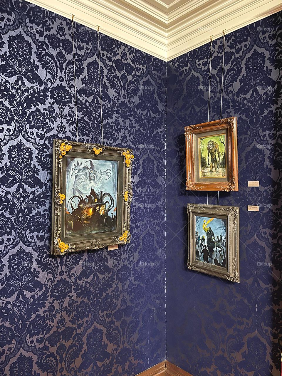 Paintings on a wallpapered wall 