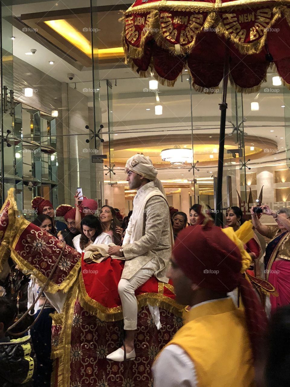 The groom at an Indian wedding on a white horse 