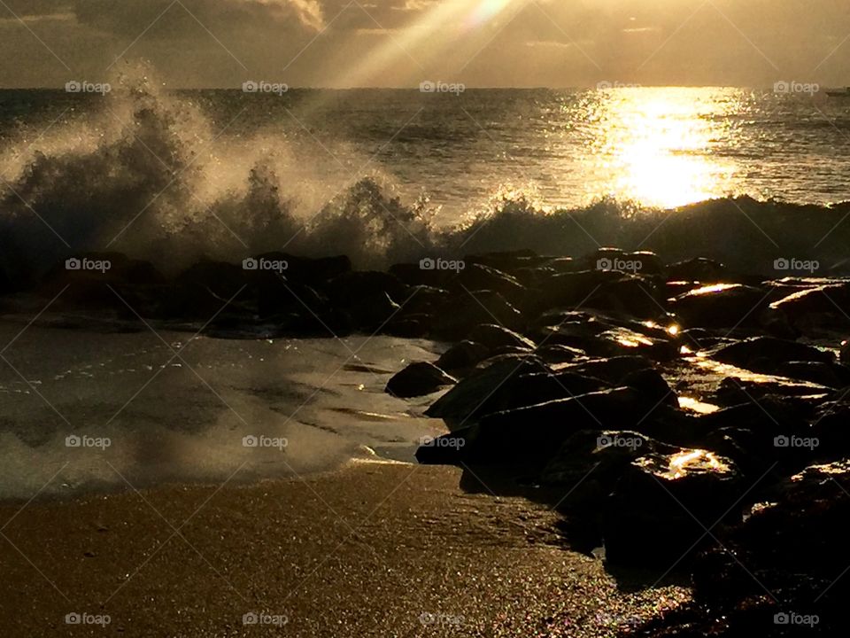 This was taken. Y Boynton beach inlet as the sunrises, it rays reflect as waves crash by the shore