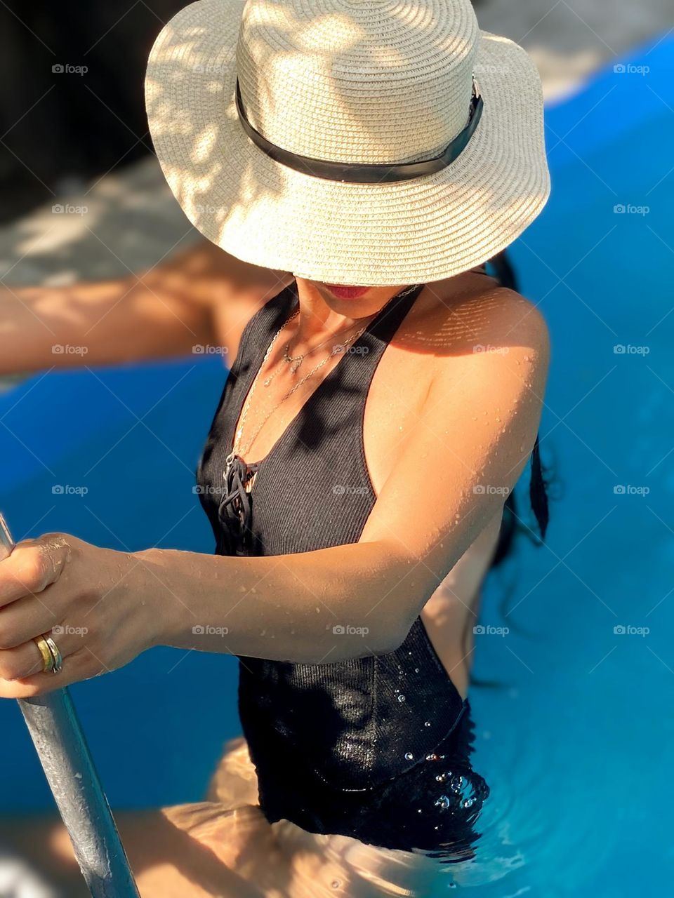 Woman in a sun hat in a pool