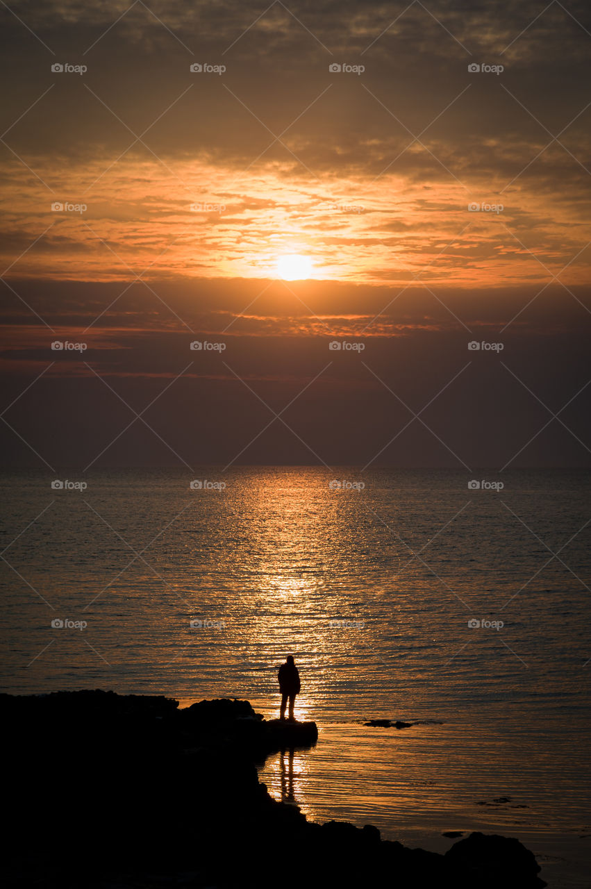 man alone admires the sunset