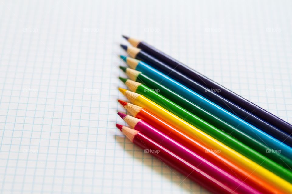 Colored pencils lined up on graph paper