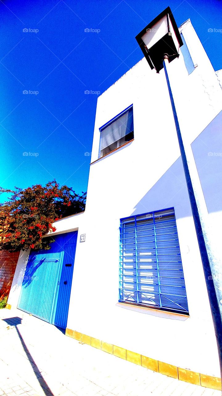 casa cierres azules buganbillas rojas