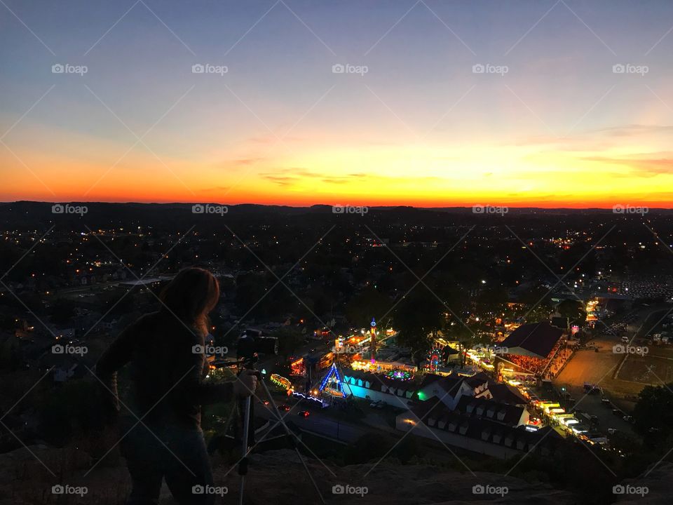 Top view of fair at night with photographer in foreground silhouetted
