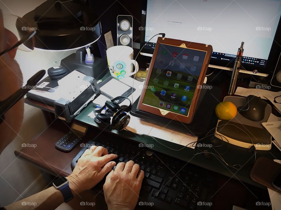 Home office desk filled with multiple gadgets.