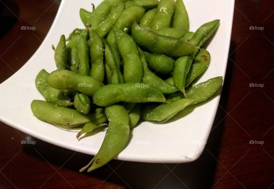 bright green delicious edamame appetizer on plate at Japanese restaurant