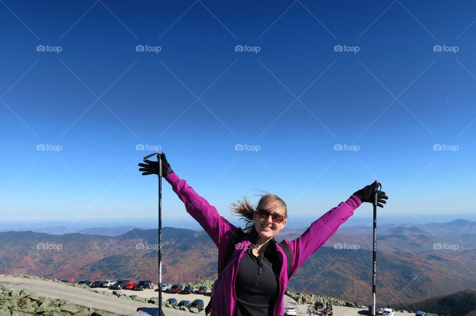 Happy hiker  with  poles on  a mountain top 
