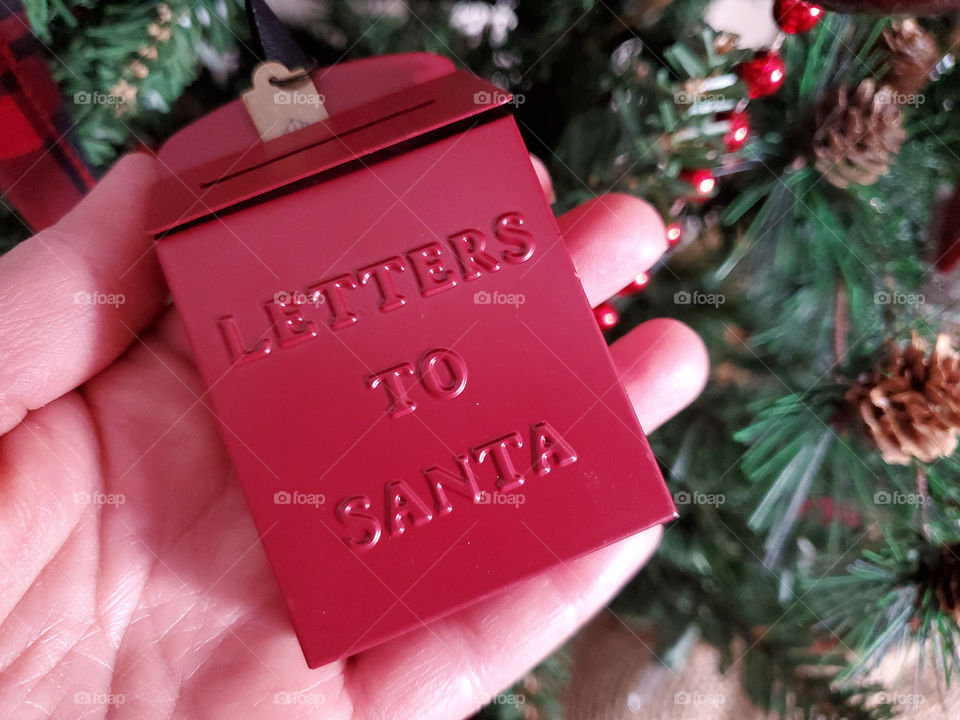 Miniature red letters to Santa mailbox with Christmas tree in the background
