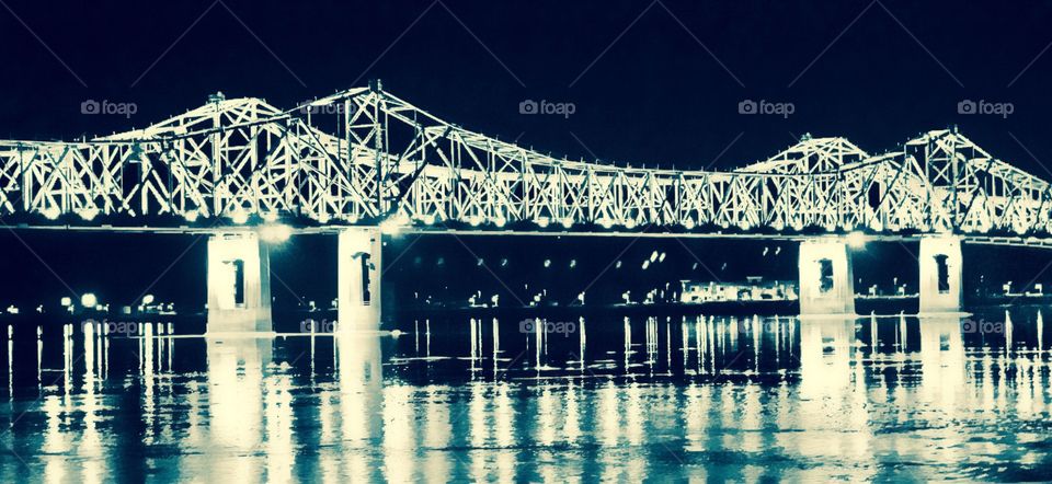 Bridge lights reflecting on the water.