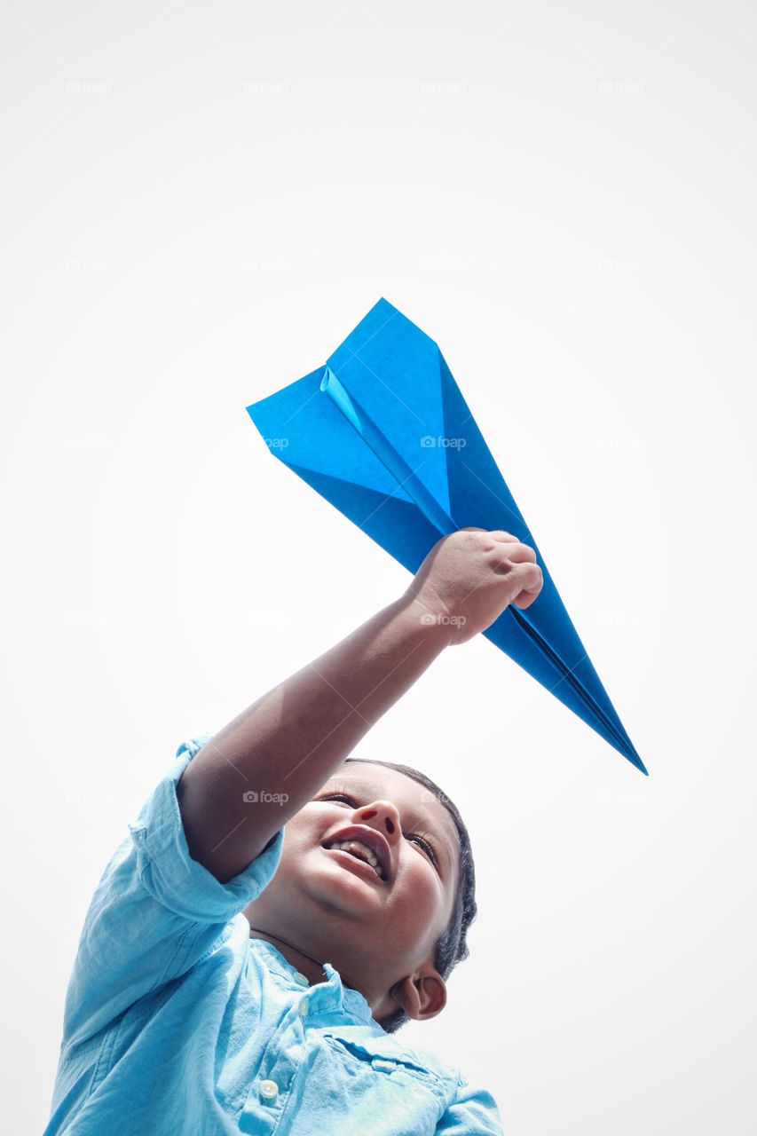 happy baby boy flying paper plane