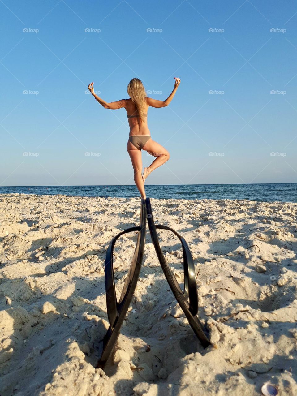 Woman doing yoga at the beach 