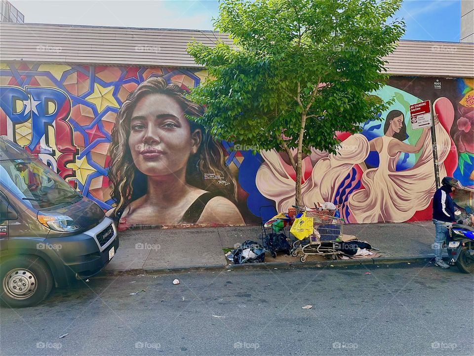 This is a hip art mural celebrating the Latin culture on “Jefferson St” off “Myrtle Ave” and “Broadway” in “Bushwick”, Bklyn. Swinging and swaying in curvaceous colorful shapes it extends over almost an entire city block. 2024. Hypnotic Productions