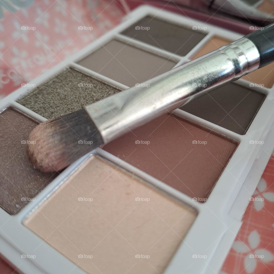 closeup of eyeshadow pallette and brush. makeup eyes brown cream