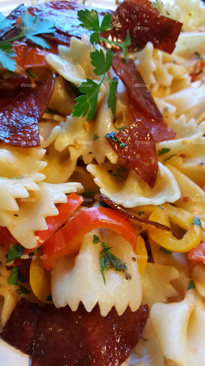 bow tie pasta with sweet peppers,  tomatoes, garlic, red pepper and crispy salami