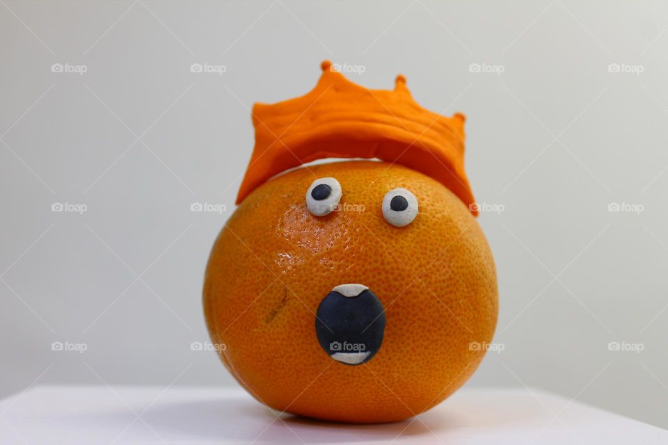 orange with a crown on his head face with surprise. bulging eyes and open mouth