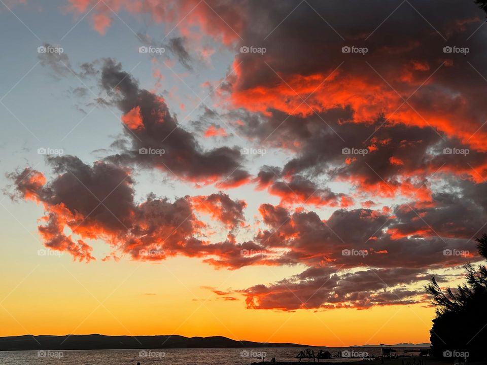 Stunning landscape view to the horizon over the Mediterranean sea with sun lighted dark clouds