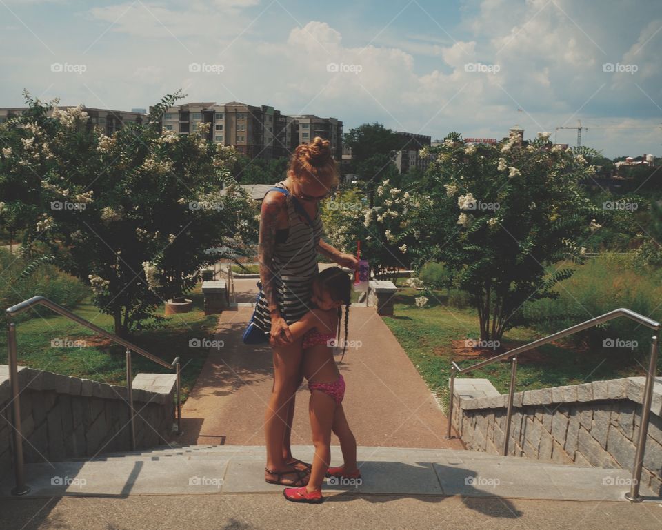 Mother and daughter standing near staircase