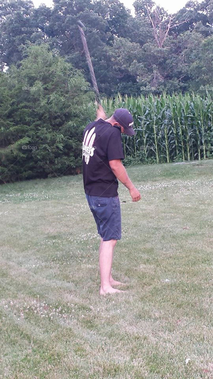 Multi-tasking. young man chats on cell phone while practicing his golf swing