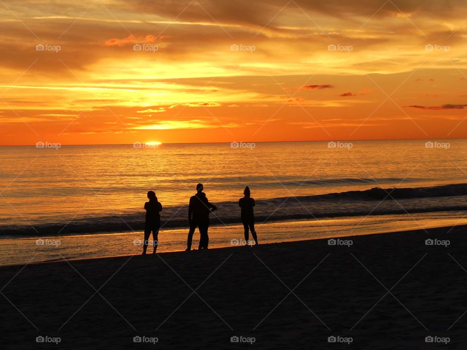 SUNSETS - A family watches sunset which is a perfect conclusion. It's the silky, smooth collusion of skyburst oranges and yellows into the calm of night