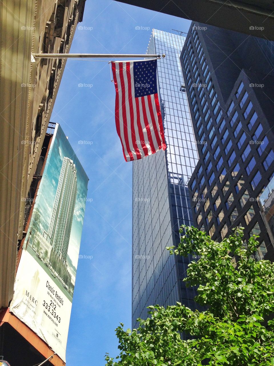 Low angle view of american flag and skycrapers