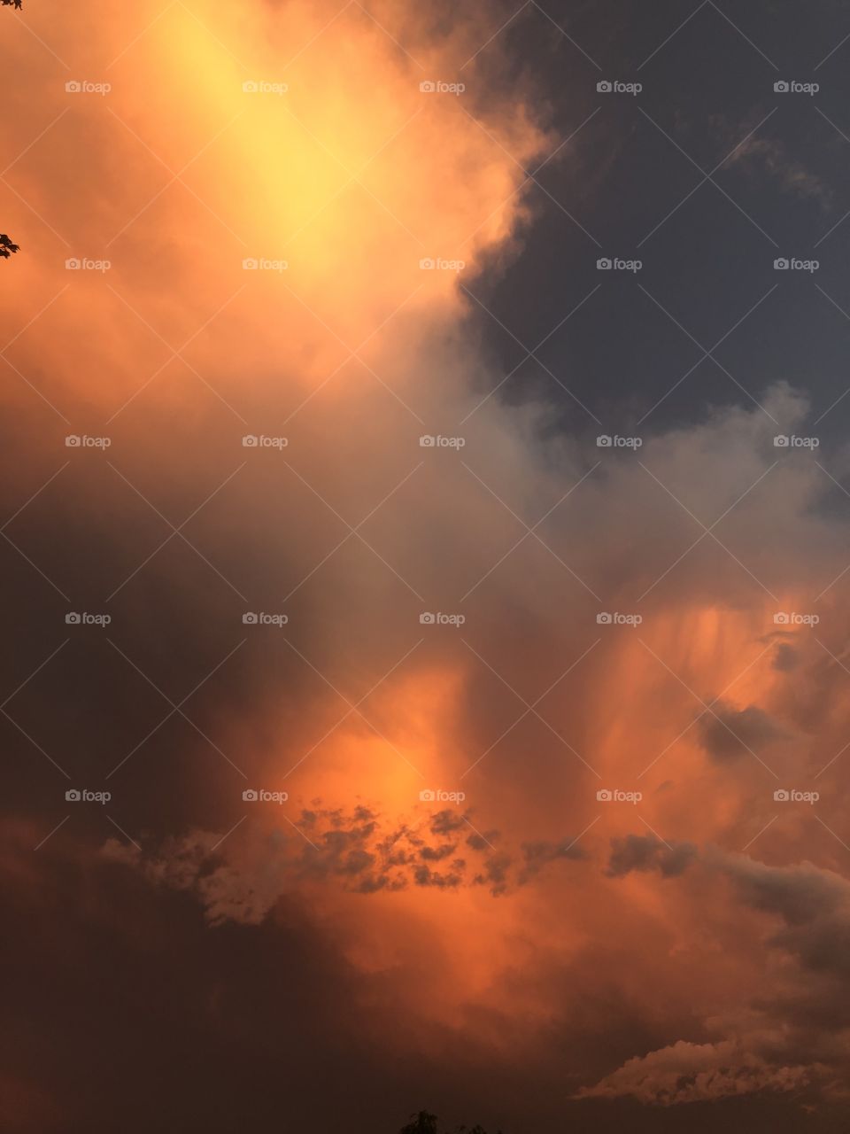 A sky that is lit up like fire as the sun behind the clouds is extraordinary. 