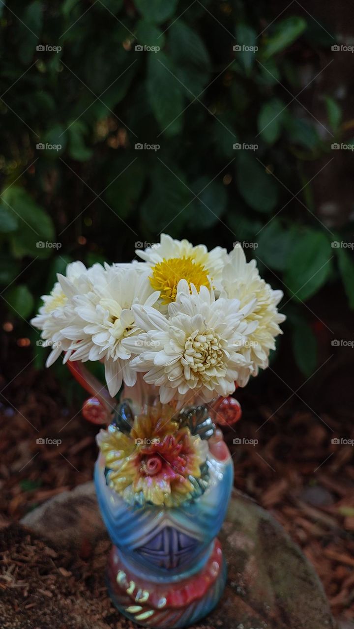 Beautiful white flowers in a colourful flowerpot with a flower sculpture, Flowers in a vase, colourful vase, white flowers in a vase