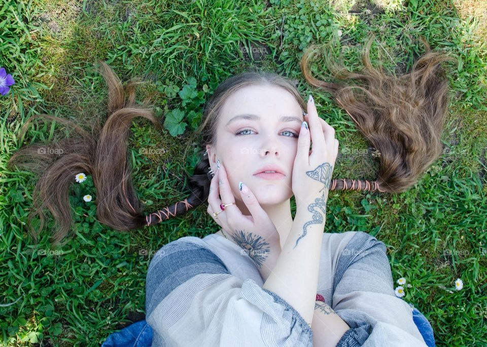 Portrait of Young Girl on Background of Daisies