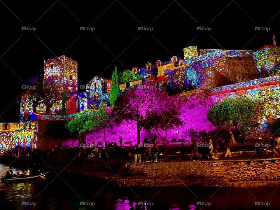 A beautiful scenery of a night lighted castle standing by a quiet beach…