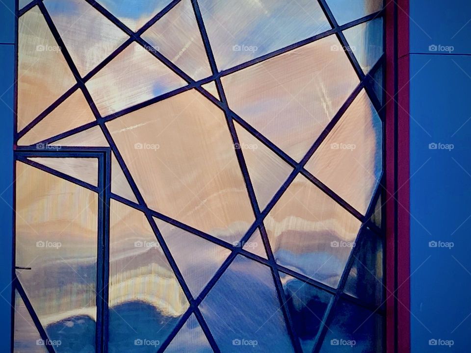 An amazing building detail: an aluminum side w overlapping black metal bars that form a „Spider-Man“ pattern and the late afternoon to early evening sun is painting the sky orange to pink at the golden hour of dusk. 2023. Hypnotic Productions