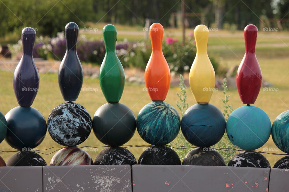 Colorful bowling pins on wall of bowling balls