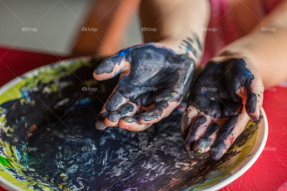 kid painting blue with hands