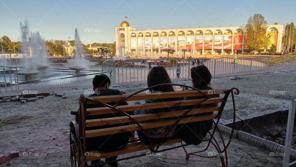 I was walking by this fountain when I saw this young people. Ut looks   like a young man has a good time being with two girls.