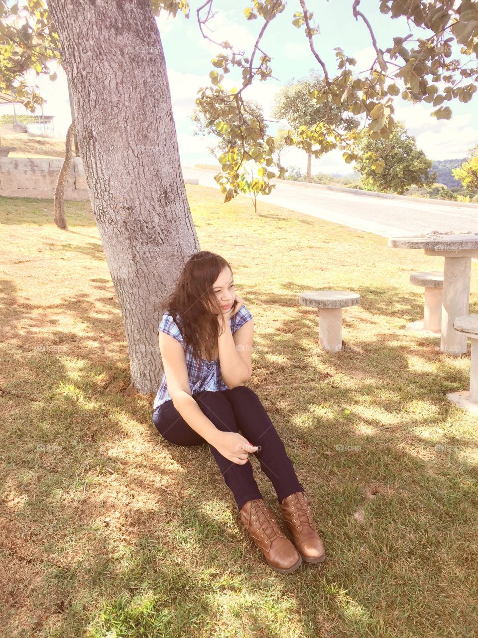 Teenage girl sitting under tree