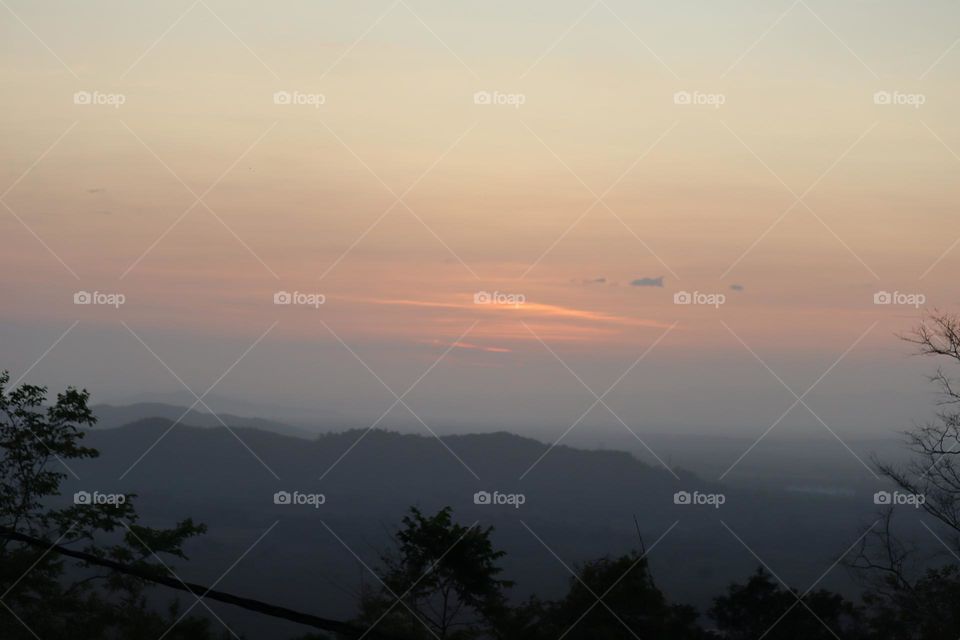 Beautiful sunrise on the horizon with fog covering the hills
