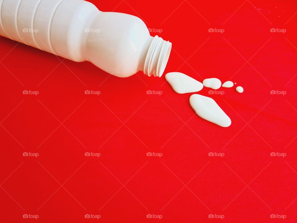 spilled milk bottle on a red background