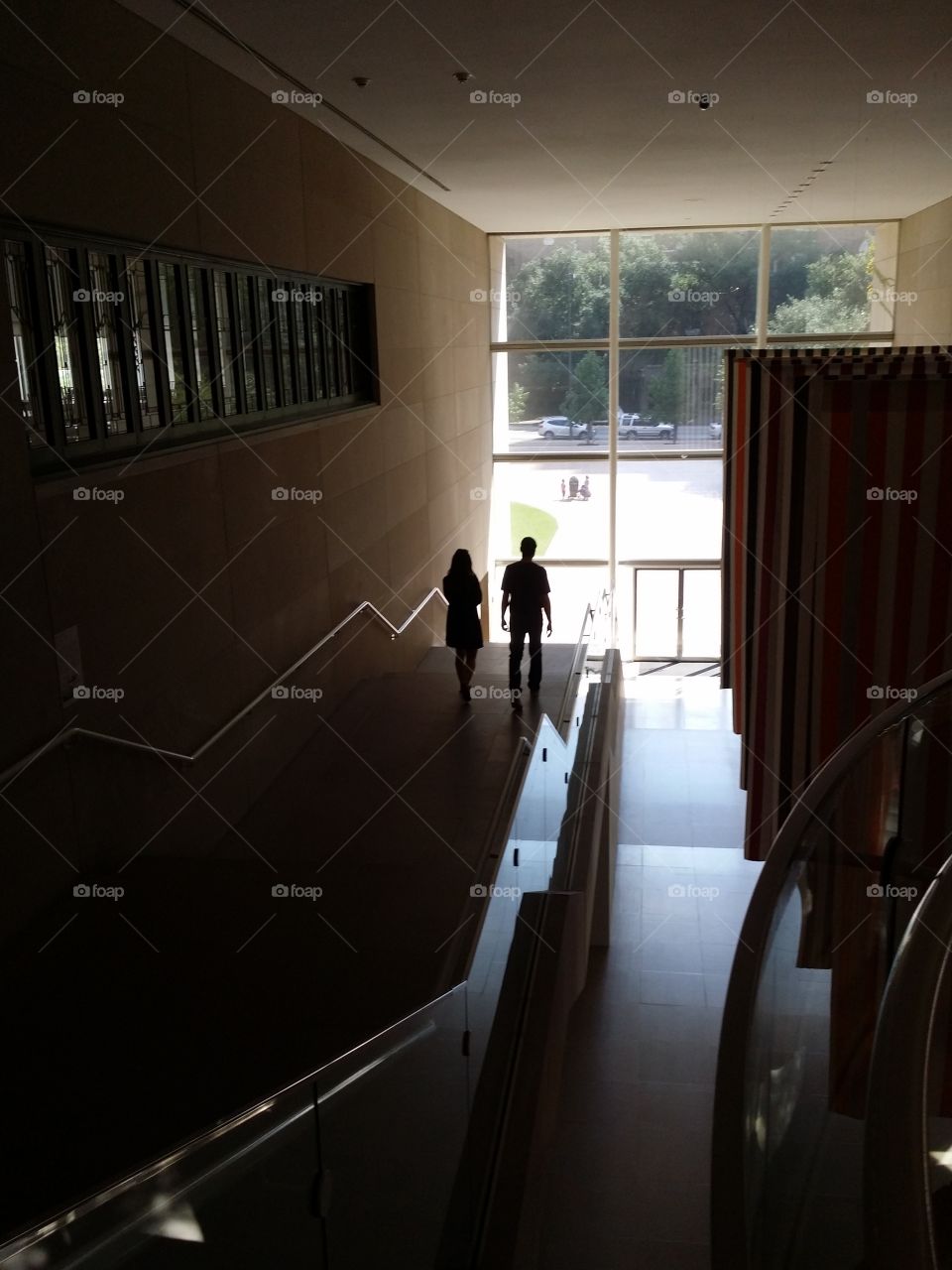 A man and a woman walking down stairs in silhouette