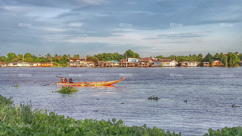 boat of Chao praya river. A long - tail boat is usually seen in Chao praya river, a main river of Thailand. People usually use this kind of boat for travelling from one side of river bank to another side.