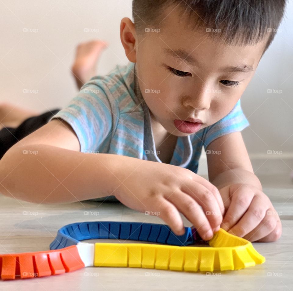 Asian boy playing with colourful toys 