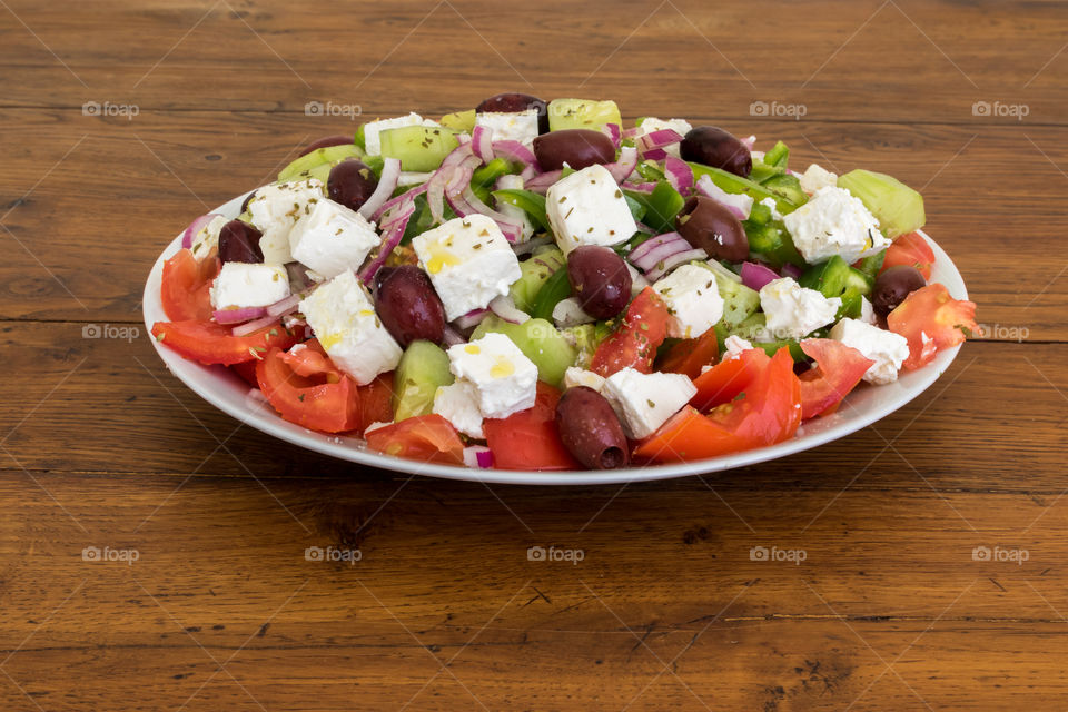 homemade Greek salad  : the main ingredients are tomatoes, cucumber, green pepper, feta cheese and kalamata olives.