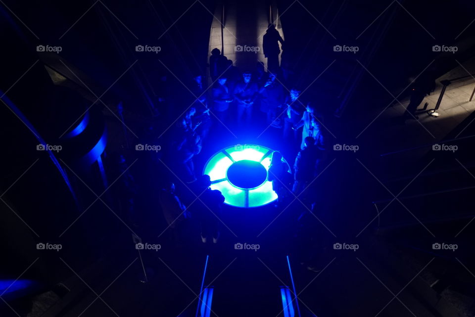 People gather around a brilliant blue light source