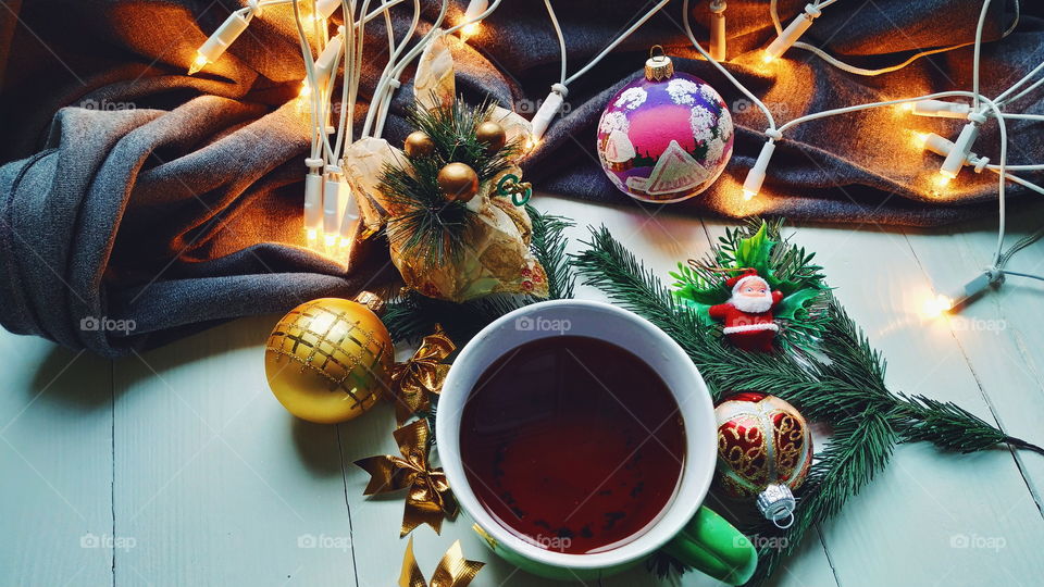 Christmas toys, a cup of hot tea, Christmas toys and garlands on a white table