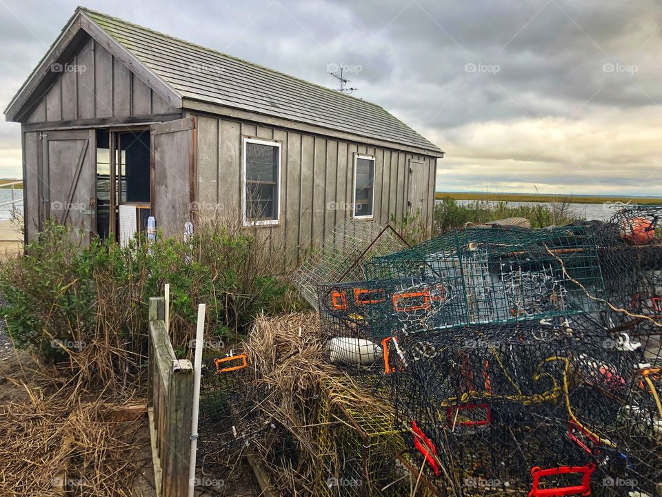 Shack by the bay with crab cages on the side.