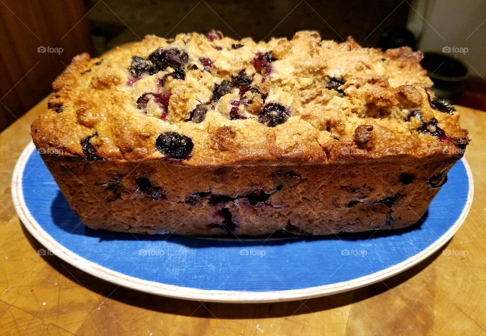 Blueberry nut bread cooling on plate, homemade, ready to eat.