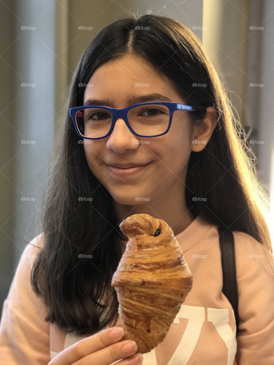 Young girl with a croissant in the morning