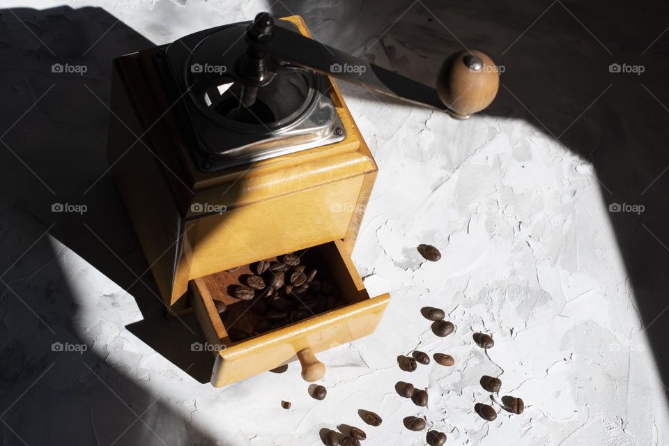 coffee beans in an old wooden coffee grinder in the sun, first coffee, the life of coffee beans