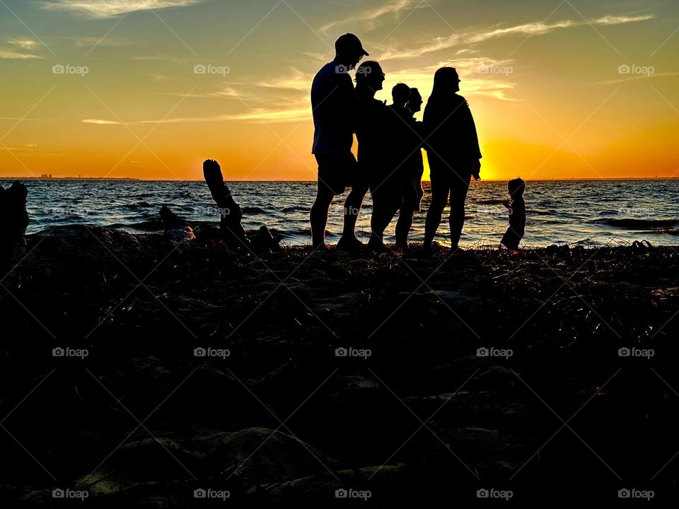 Silhouette of a family enjoying the spectacular sunset -  Landscape photography is a genre of photography that captures natural landscapes