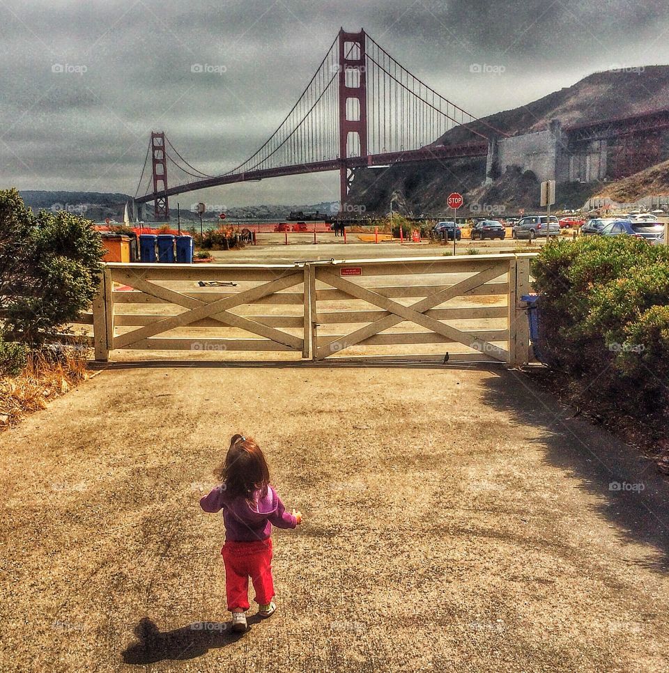 Toddler In San Francisco. Little Girl Running Toward Golden Gate Bridge
