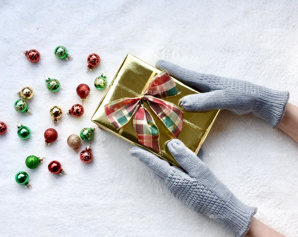 Woman holding Christmas gift and Christmas bulbs 