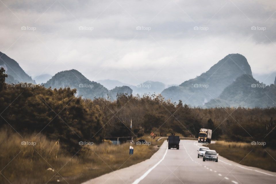 Far view of a rural road with some cars on the road